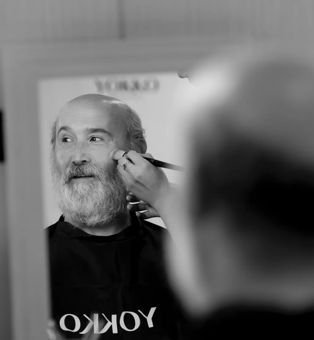 Actor con barba blanca siendo maquillado en el backstage del FesTVal de Vitoria-Gasteiz, fotografía en blanco y negro de Josu Izarra